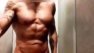 Mec musclé se branle sous la colour up rinse de la salle de game
